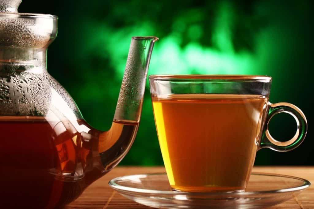 hot green tea in glass teapot and cup